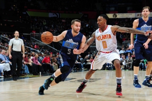 J.J. Barea mentre cerca di eludere la marcatura di Jeff Teague