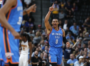 Oklahoma City Thunder guard Russell Westbrook gestures to forward Kevin Durant after Westbrook dunked on a pass from Durant, late in the second half of an NBA basketball game against the Denver Nuggets on Tuesday, Jan. 19, 2016, in Denver. The Thunder won 110-104. (AP Photo/David Zalubowski)